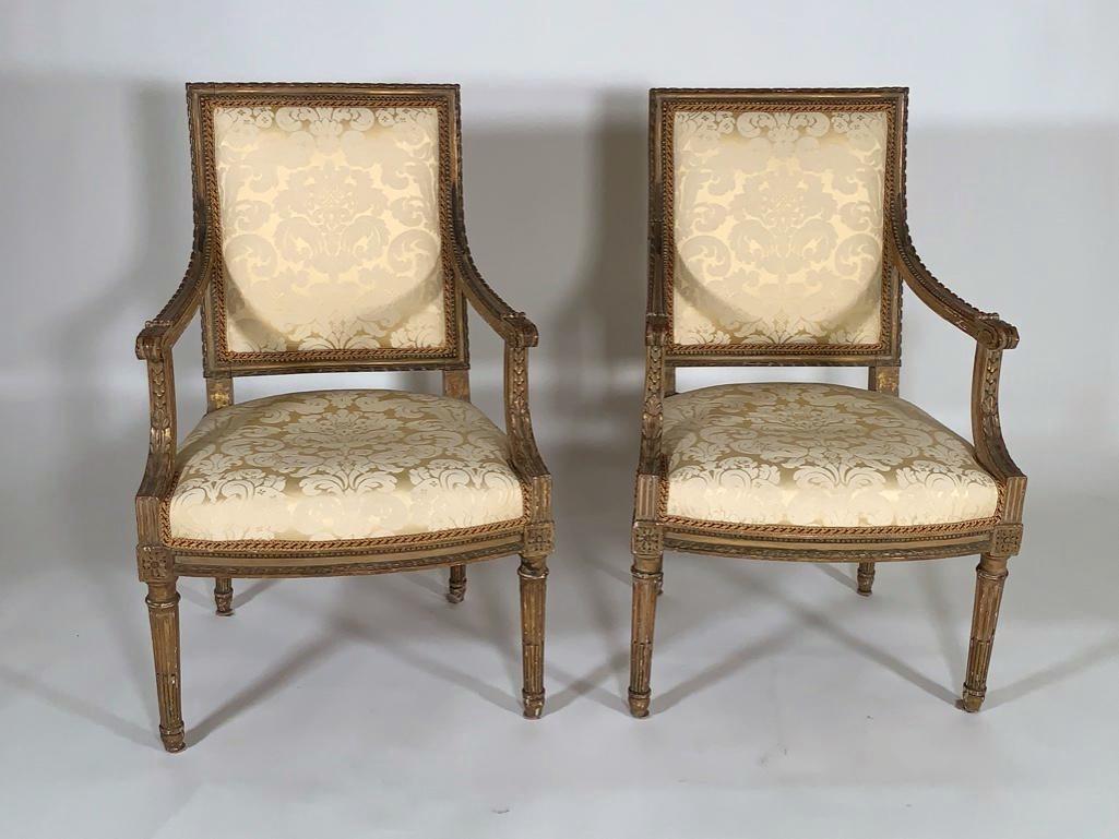 Pair of Louis XVI Gilt Wood Fauteuils, 18thc.: Pair of Louis XVI Gilt Wood Fauteuils, 18thc. Squared backs with carved ribbon detail over downswept arms and upholstered seats raised on turned tapering stop fluted legs. Upholstered in pale yellow s