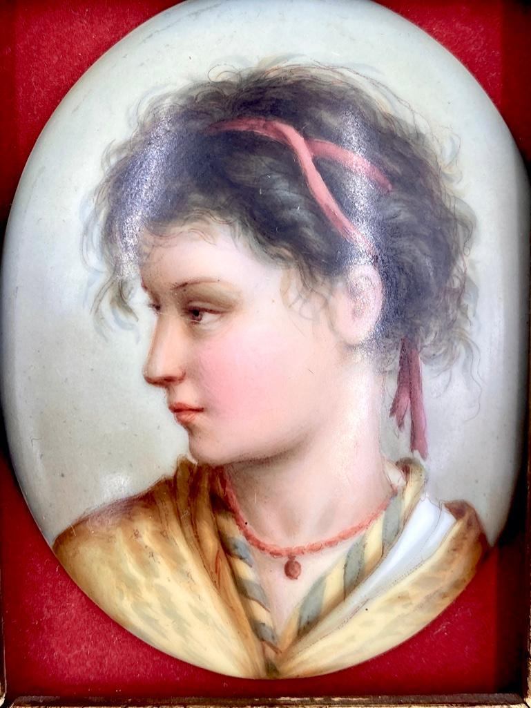 Small KPM Porcelain Plaque of a Gypsy: Small KPM Porcelain Plaque of a Gypsy, the oval form han painted with a profile portrait of a young gypsy girl, with ribbon tied hair and coral necklace. In giltwood frame. Dimensions: Plaque is 3.25 