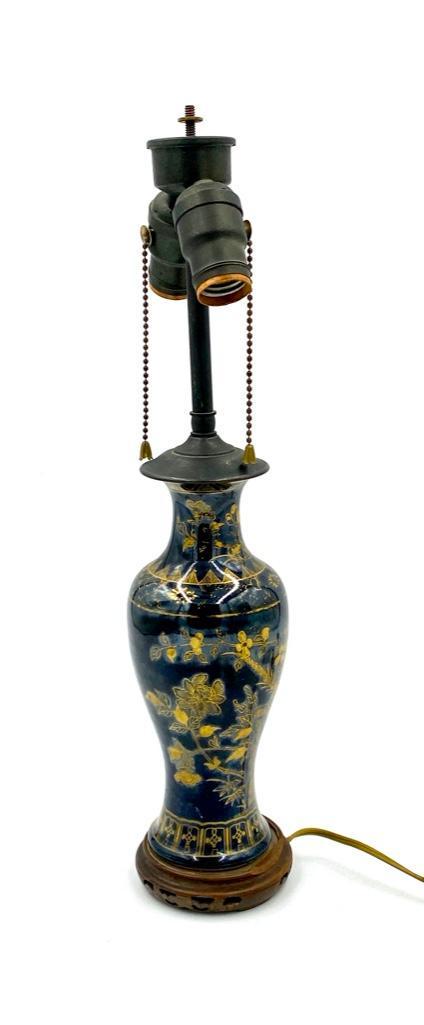 Chinese Porcelain Boudoir Lamp: Chinese Porcelain Boudoir Lamp, or small table lamp, of baluster form in mirror black glaze decorated in gilding with birds on flowering branches. Raised on wood base. Dimensions: 11 in.h. to top of v