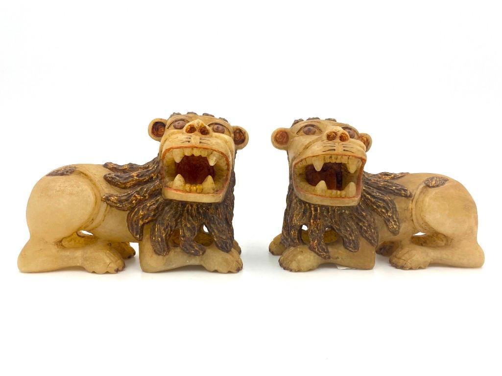Pair of Peruvian Huamanga Carved Alabaster Lions: Pair of Vintage Peruvian Huamanga Carved Alabaster Lion, crouching lion form carved in alabaster and highlighted with pigment and gilding. Dimensions: 3.5 in.x 5 in. Condition: Very good with no damag