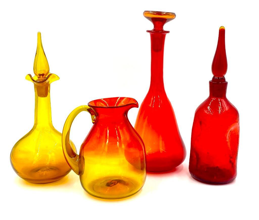 Blenko and Other Modern Glass: Blenko and Other Modern Glass, comprising a Tangerine pitcher, Decanter with stopper, Crackle decanter with stopper, and a yellow decanter with stopper. Dimensions: 14.5 in.h. of tallest. ,br>Condi