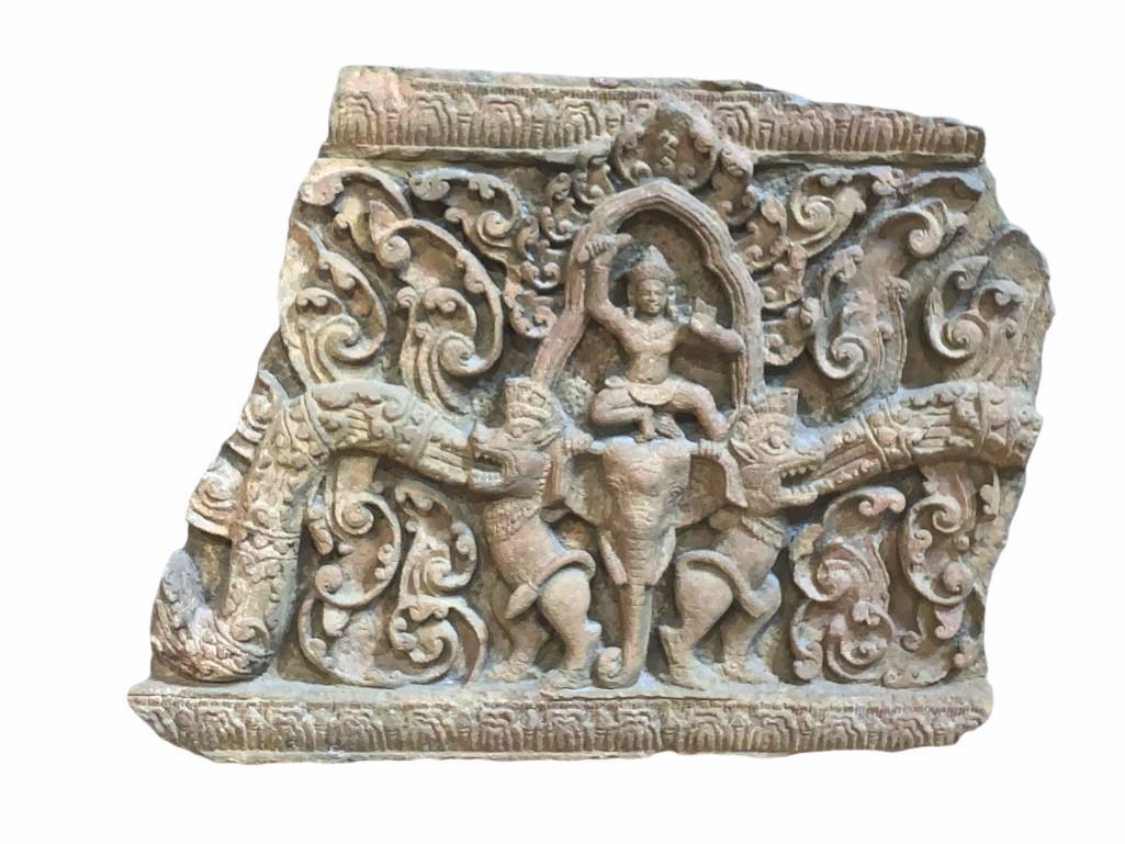 Cambodian Khmer Carved Stone Temple Relief: Cambodian Khmer Carved Stone Temple Relief, centered by Shiva in a dancing pose on top of an elephant head, flanked by fierce guardian figures and carved scroll forms. Dimensions: 28 in.h. x 34 in.w. 