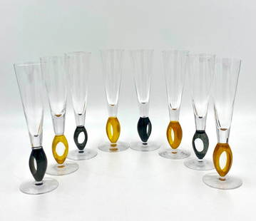 Kosta Boda Ann Wahlstrom Champagne Flutes: Kosta Boda Ann Wahlstrom Champagne Flutes, eight flutes, four in black, four in yellow, each signed. Dimensions: 10 in.h. Condition: Very good with no damage or restoration. The images provided cons