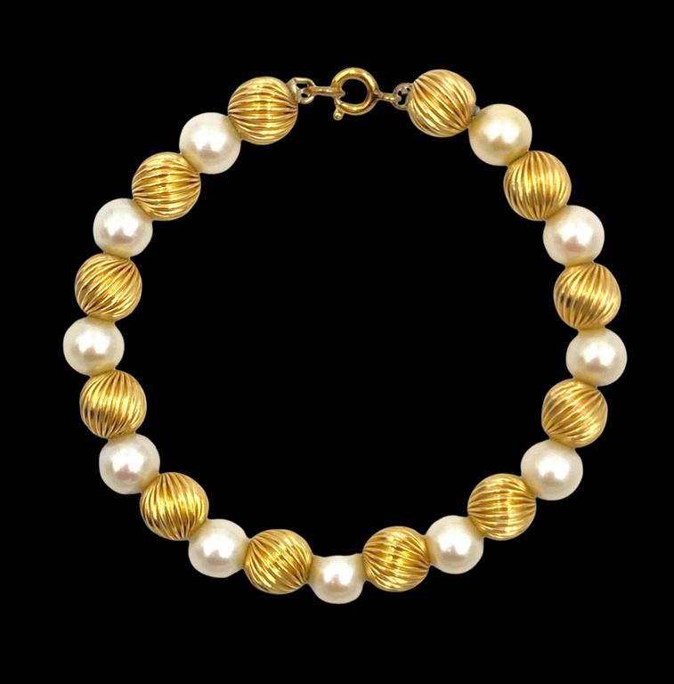 Pearl and Gold Bead Bracelet: 14K yellow gold Pearl and Gold Bead Bracelet, with eleven (11) apprx 7mm pearls and twelve (12) ribbed hollow gold beads. Simple clasp, apprx 13 grams and 7.5 in.l.