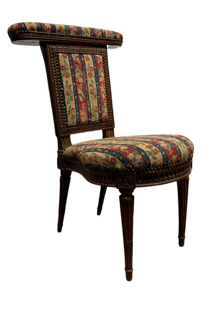 Louis XVI Period Cock Fighting or Reading Chair, 18thc.: Louis XVI Period Cock Fighting or Reading Chair, 18thc. In walnut or fruitwood, with needlepoint upholstered toprail and back over a shaped needlepoint upholstered seat, with carved seat rail, raised 