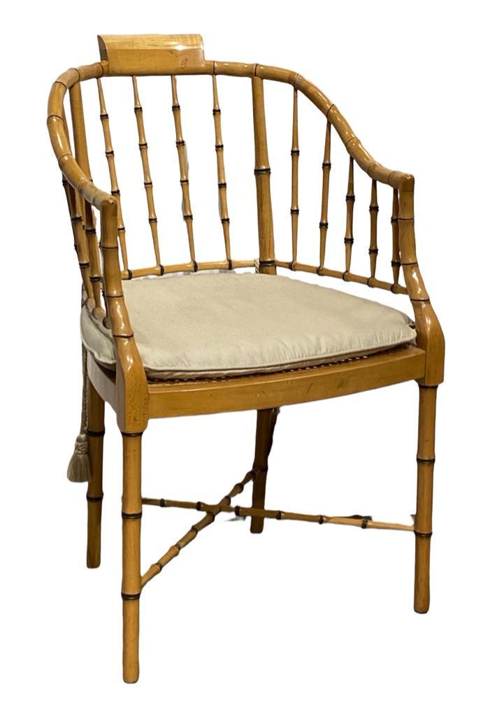 Baker Furniture Faux Bamboo Tub Chair: Baker Furniture Faux Bamboo Tub Chair, with bamboo spindles over caned seat, fitted with silk cushion with tasseled ties. Dimensions: 35 x 21 x 18 in. Seat ht. 19 in. Condition: Very good.