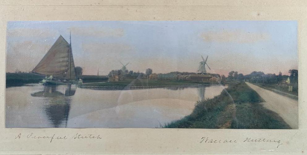 Wallace Nutting "A Peaceful Stretch": Sailboat sails towards windmill in distance, Wallace Nutting Ref#5093, 10 x 19 inches,antique silver gelatin photograph with original hand coloring, framed, under glass. Not inspected out of framing.