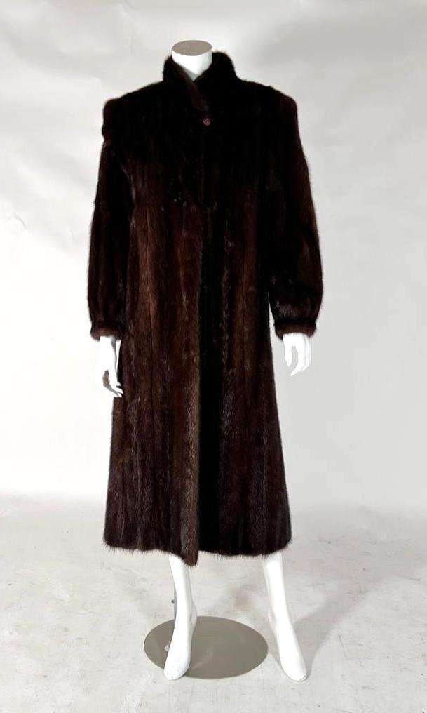 Full Length Mink Coat: Ranch mink, label by Evans, lined, monogrammed. Hook clasp front, pockets, blouson sleeves, decorative button at collar. Arm length 24", overall length 47". Condition: Pre-owned, very good.