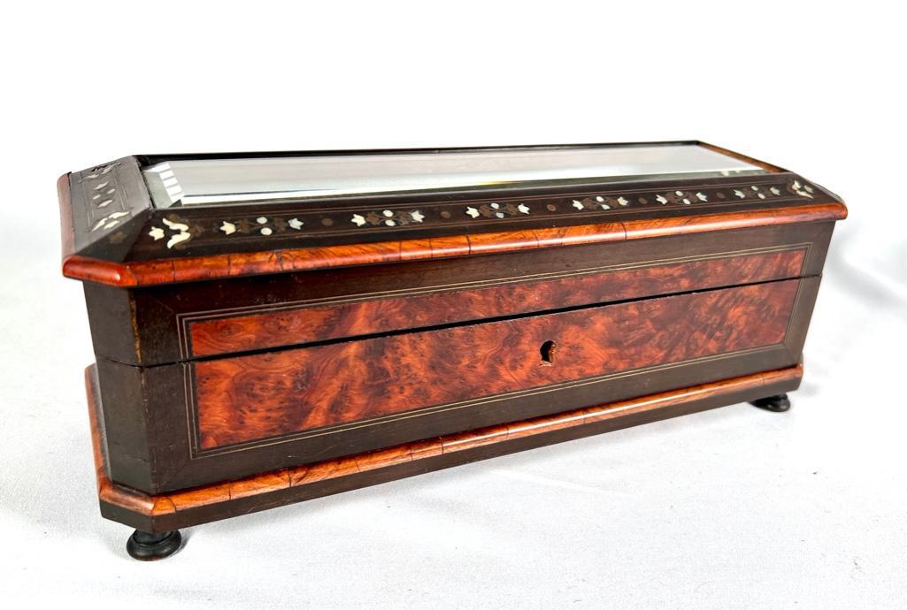 Figured and Inlaid Wood Glove Box, 19thc.: Figured and Inlaid Wood Glove Box, 19thc. of rectangular form with inset beveled glass, inlaid with mother of pearl, the hinged top opening to a satin lined interior, raised on bun feet. Dimensions: 5