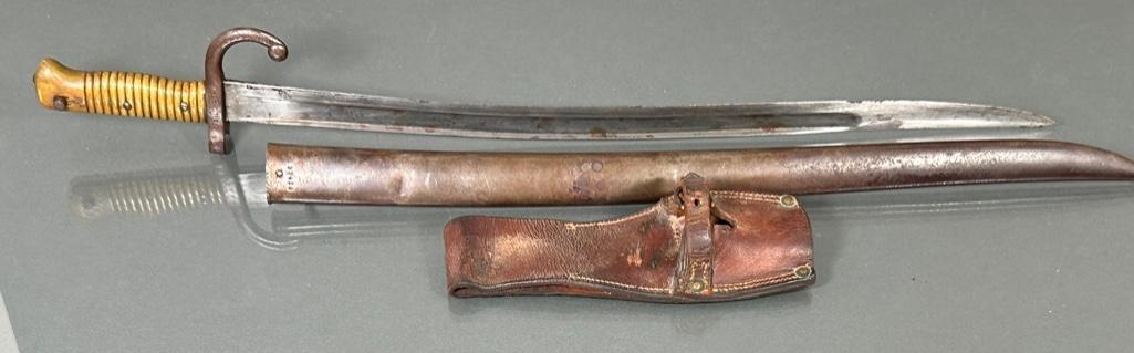 1869 French Sword-Bayonet: With scabbard and frog, top of blade marked, with brass handle. Condition: good.