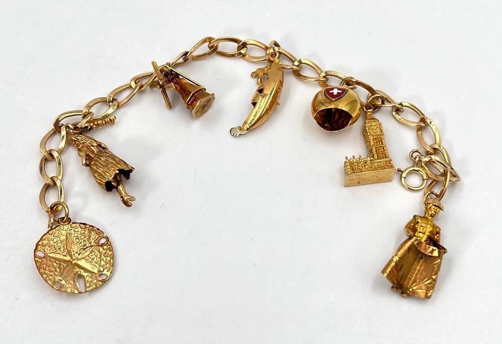 14K Gold Charm Bracelet: 14K Gold Charm Bracelet, having seven charms of major world cities on a bright gold link chain, apprx 7"L, however adjustable with its lobster claw clasp. Condition: very nice!