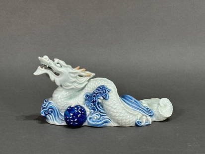 Japanese Hirado Porcelain Dragon: Japanese Hirado Porcelain Dragon, probably 1850-1890, represents the sculptural tradition in the Hirado kilns. The rare magnificently sculpted dragon, an okimono, sails on the cosmic sea clutching a b