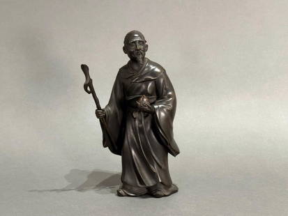 Japanese Bronze Figure of a Sennin By Shosei, Meiji Period: Japanese Bronze Figure of a Sennin By Shosei, Meiji Period, the standing scholar wearing kimono robe cinched with an obi, holding a staff and a peach of immortality, inscribed signature to obverse. Di