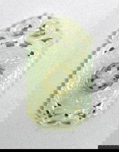 Chinese Carved Jade: Chinese Carved Jade Ornament, is comprised of a central bi disc form with plant motifs at top and bottom. Stylize taotie masks, carved in slight relief, encircle the form. These designs recall their a