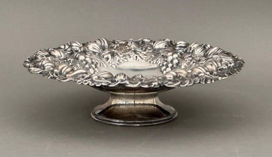 Barker Brothers English Silver Plate Compote 12": Barker Bros. plated silver compote with an incredible repousse rim with fruits, flowers, vines, leaves and grapes. Hallmarked underneath, made in England. Dimensions: 12.5"D x 3.75"T. Condit