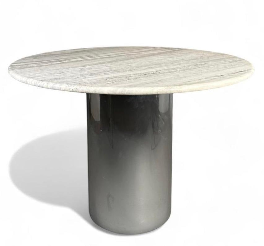 Brueton Anello Dining Table: Brueton Anello Dining Table, circular marble top on chromed cylindrical base. Dimensions: 29.5 in.h. x 42 in. dia. Condition: Very good with light wear from use.
