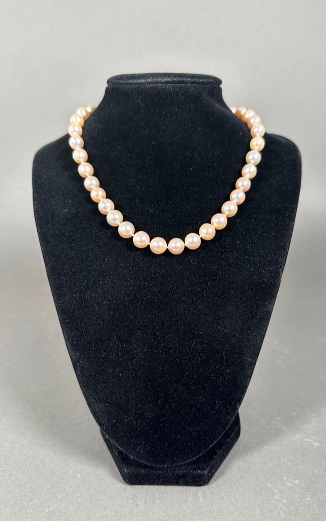 Fresh Water Pearl Necklace: 37 hand strung and knotted fresh water pearls which are slightly baroque, having a champagne color and iridescent nacre. Each well matched pearl is apprx 8mm. Unmarked white metal clasp, apprx 14"