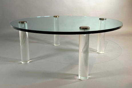 Modern Glass and Lucite Coffee Table: Modern Glass and Lucite Coffee Table, the circular top raised on four cylindrical lucite legs with metal capped tops. Dimensions: 16 in.h. x 43 in. dia. Condition: Some chips to one side of top at