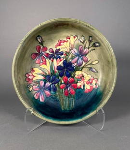Moorcroft Pottery Bowl, Spring Flowers Pattern: Moorcroft Pottery Bowl, Spring Flowers Pattern, large center bowl form decorated with colorful flowers on a green ground. Signed in underglaze blue to the base and stamped Potter to H.M. The Queen. 