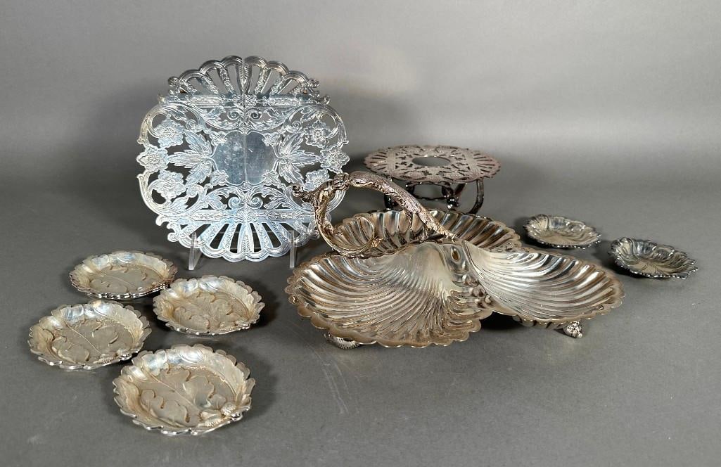 Assorted Lot of Silver Plate: Assorted Lot of Silver Plate, comprising a tri-part scallop shell serving dish on shell feet, a trivet, a warming stand, five small oak leaf and scorn dishes and two small leaf shaped dishes. Dimensio