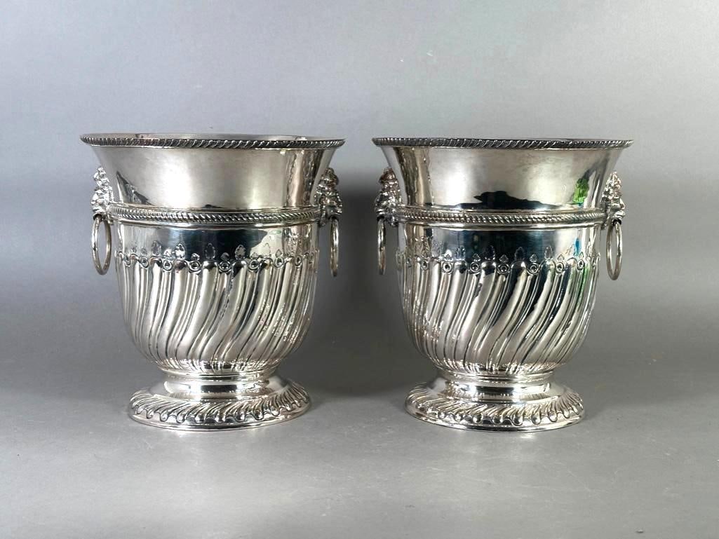 Pair of Georgian Style Silver Plated Wine Coolers: Pair of Georgian Style Silver Plated Wine Coolers, with lion and mask ring handles, gadrooning and shaped leaf decoration. Dimensions: 9.25 in.h. x 8.75 in. dia. of top. Condition: Some dents, wear an