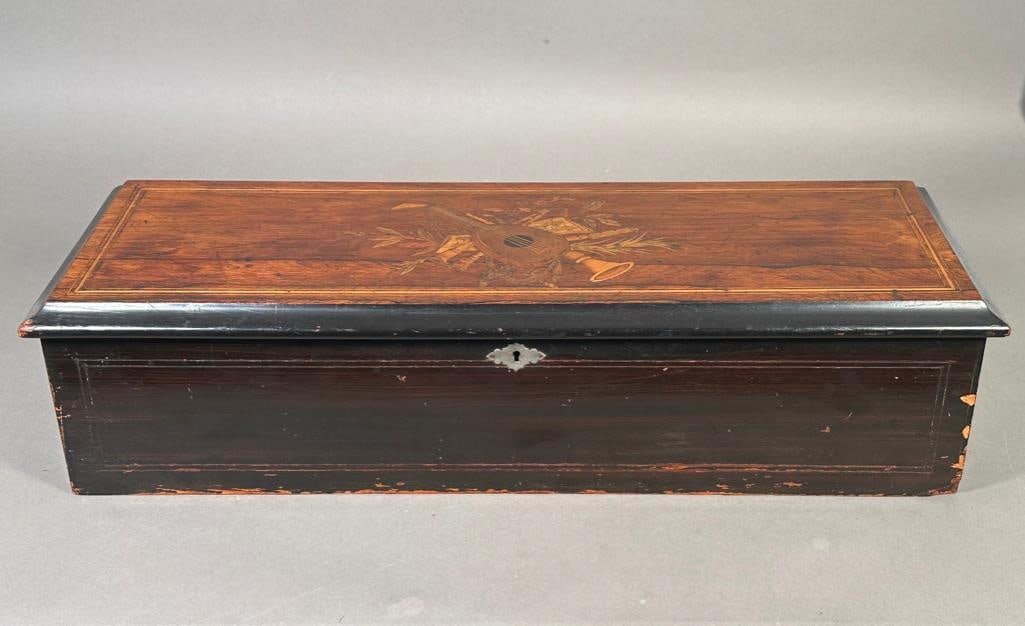 Swiss Cylinder Music Player: Inlaid decorative box, hinged lin and interior glass cover. Ten song player with comb, teeth appear to be intact. In working order but may need service/cleaning as interior is oily and dusty. Measures