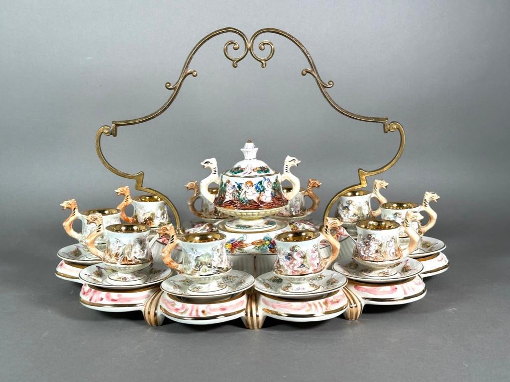 Capodimonte Demitasse Stand, 20thc.: Capodimonte Demitasse Stand, 20thc. Including 10 gilt washed cups and saucers with chimera handles, on fitted stand with metal handle, centered by a matching sugar bowl. Dimensions: 13 x 21 x 14 in. C