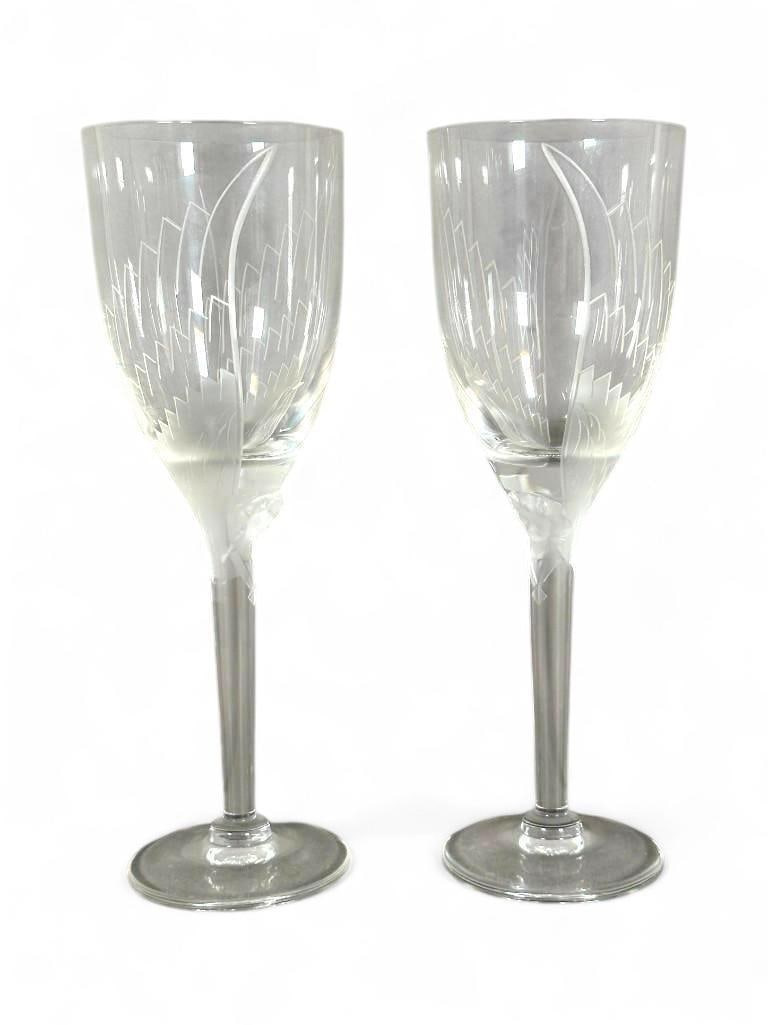Pair of Lalique Angel Crystal Champagne Flutes: Pair of Lalique Angel Crystal Champagne Flutes, in clear crystal molded at the top of the stem with an angel face, with acid etched wings. Incised Lalique France signature. In original box. Dimensions