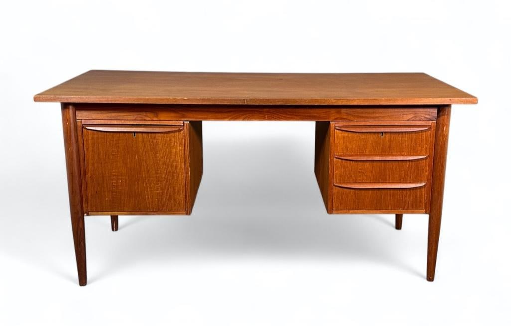 Mid Century Modern Teak Desk: Mid Century Modern Teak Desk, Rectangular top over file drawer on left and three drawers on the right, raised on turned tapering legs. Dimensions: 29.5 x 60.25 x 29 in. Condition: Mold damage to back