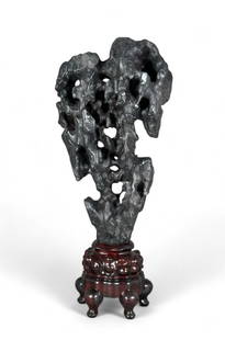 Chinese Carved Stone Scholar's Rock in Stand: Chinese Carved Stone Scholar's Rock in Stand, Modern. Dark slate grey stone with veining resembling a natural rock form or mountain, in fitted wood stand. Dimensions: 27 in. total ht. x 12 in.w. C
