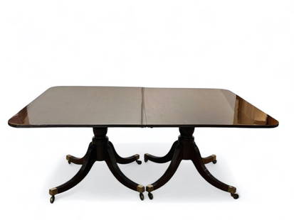 Hepplewhite Dining Table: Carved mahogany Hepplewhite dining table, rounded rectangular table top on down swept, reeded, double pedestals ending in brass sabots over castors. One leaf present. Condition: Very good, repair to c