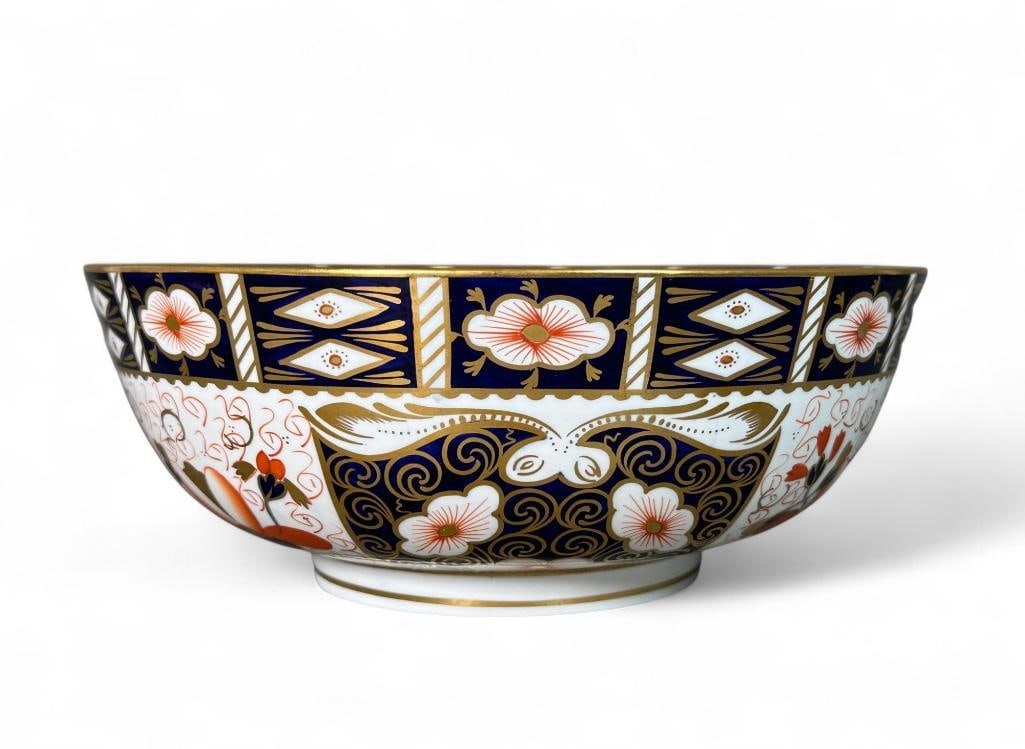 Royal Crown Derby Imari Bowl: Made in England, pattern number 2451, iron-red mark. Footed bowl with blue-black and red-orange on white ground with gold details. Both interior and exterior decorated with flowers and shapes in reser