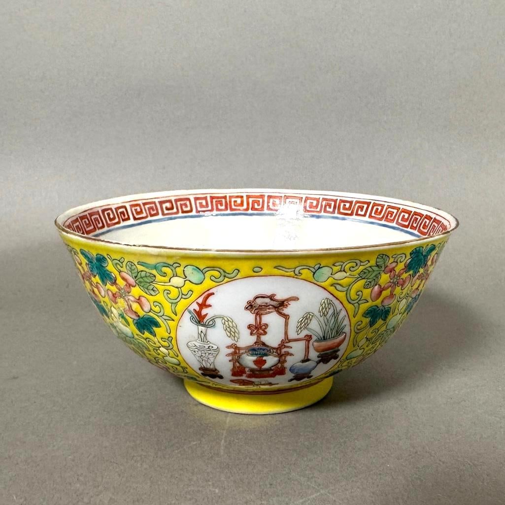 Chinese Famille Jaune Rice Bowl: Chinese Famille Jaune Rice Bowl, footed form decorated with precious objects in circular reserves on a yellow ground decorated with pendant double gourds on vines. Six character mark of Guangxu to bas