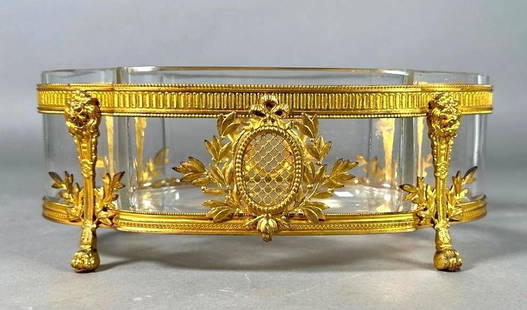 French Crystal Bronze Mounted Center Bowl, 19thc.: French Crystal Bronze Mounted Center Bowl, 19thc. The shaped oval bowl in clear crystal fitted into a gilt bronze base cast with lattice work cartouches and wreaths, raised on four lion mask terms end