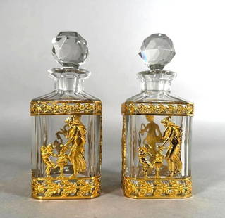 Two Napoleon III Gilt Bronze Mounted Scent Bottles, The Four Seasons: Two Napoleon III Gilt Bronze Mounted Scent Bottles, squared forms in clear crystal fitted with gilt bronze mounts cast with maidens and cherubs emblematic of the Four Seasons. Dimensions: 5.75 in.h. C