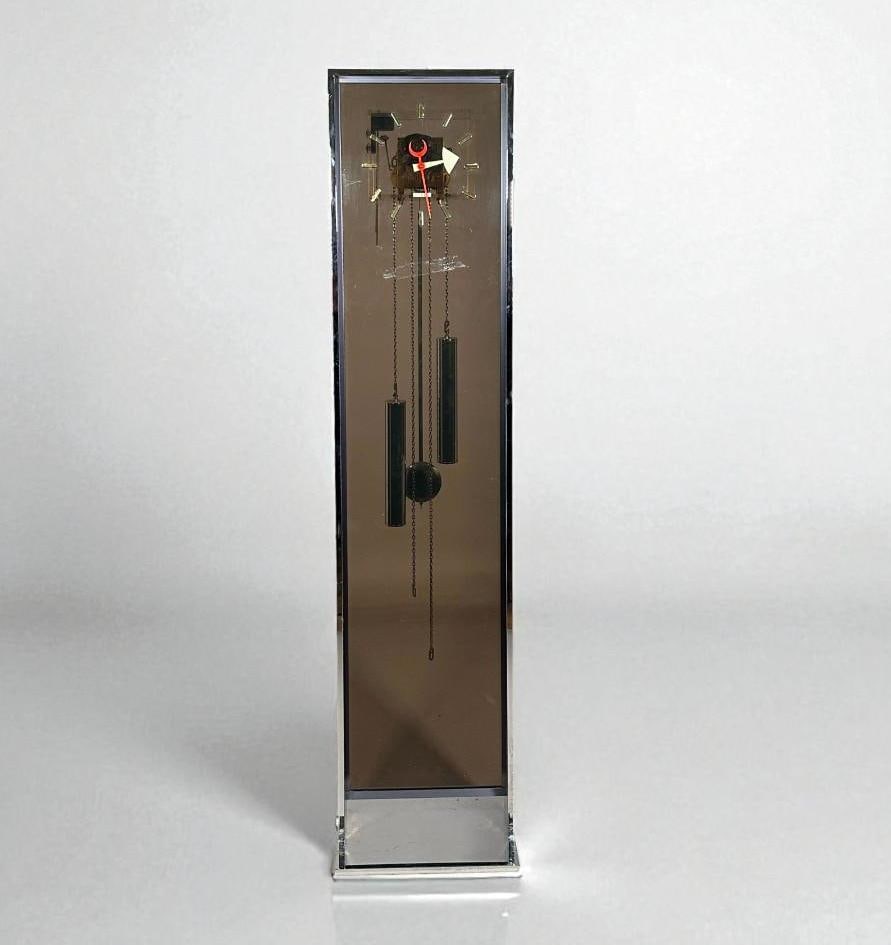 George Nelson for Howard Miller Standing Case Clock: George Nelson for Howard Miller Standing Case Clock, the rectangular case in chrome, with smoky glass face with enameled metal hands, with visible works, with two weights and a pendulum. With Howard M