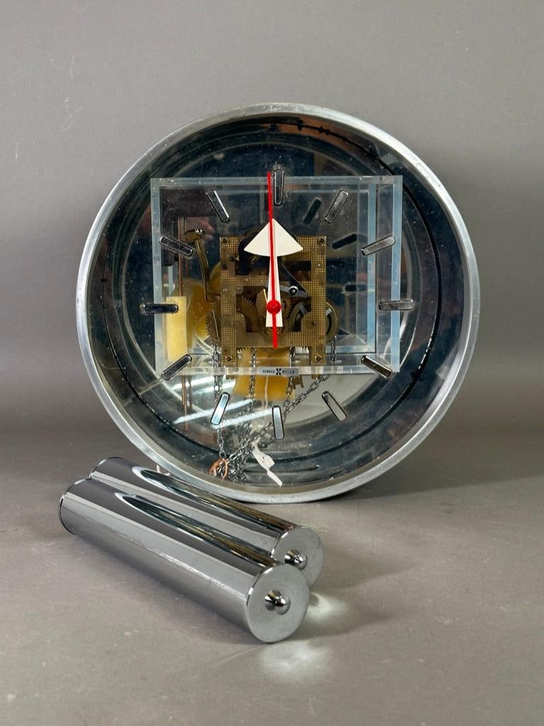 George Nelson for Howard Miller Wall Clock Model No. 618: George Nelson for Howard Miller Wall Clock Model No. 618, the circular case in brushed aluminum, with lucite face with enameled metal hands, with visible works over a mirrored back, with two weights.