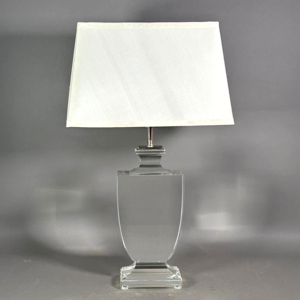 Regina Andrew Design Crystal Table Lamp: Regina Andrew Design heavy crystal lamp with a flat urn form on a rectangular tiered base. Perfectly clear and very heavy. Accompanied by pristine white lampshade. Dimensions: 16 in.h. to socket 26.5