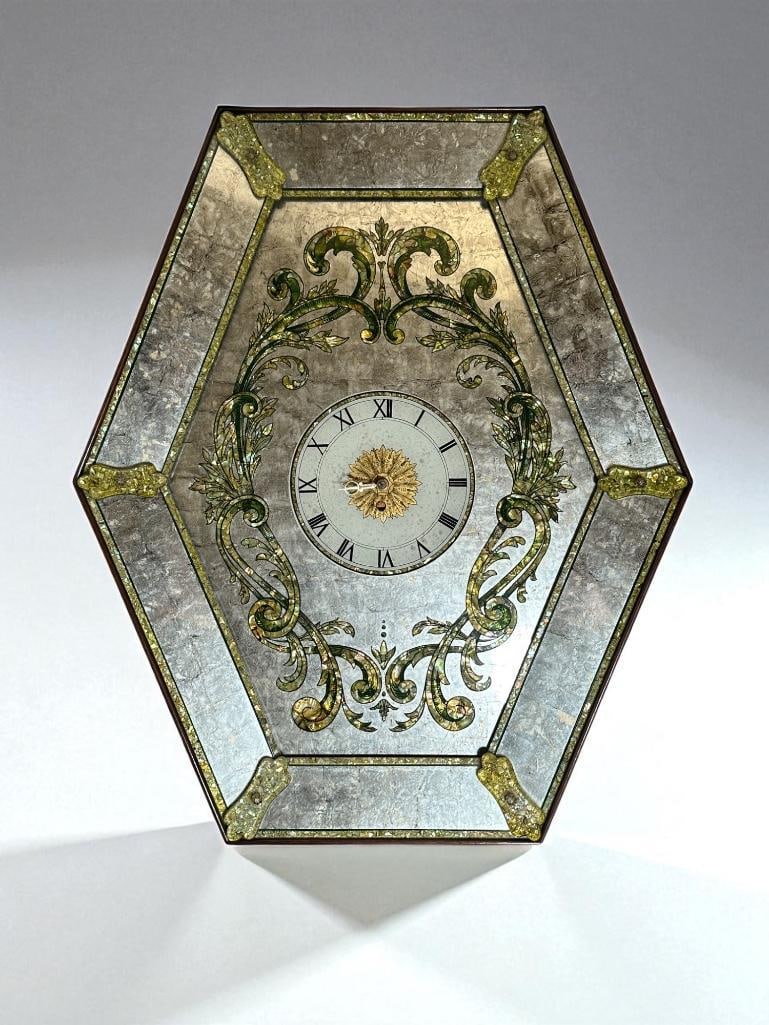 Large 1950's Venetian Style Mirrored Wall Clock: Large 1950's Venetian Style Mirrored Wall Clock, hexagonal frame with antiqued mirror surface with green foliate scroll design, the face with roman numerals. Dimensions: Apprx 30" x 20". Provenance: C