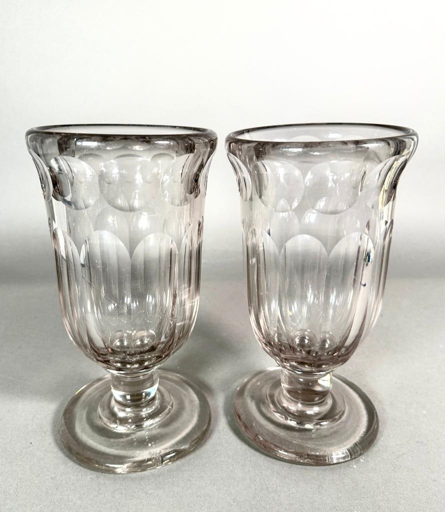 A Pair of Anglo-Irish Glass Vases, 19th century: Clear glass mold form vases, raised on round foot. Optic cut with discs at rim and fluted body. Unsigned or marked, apprx 10T x 5.5D. Condition: wear to bottom of bases.