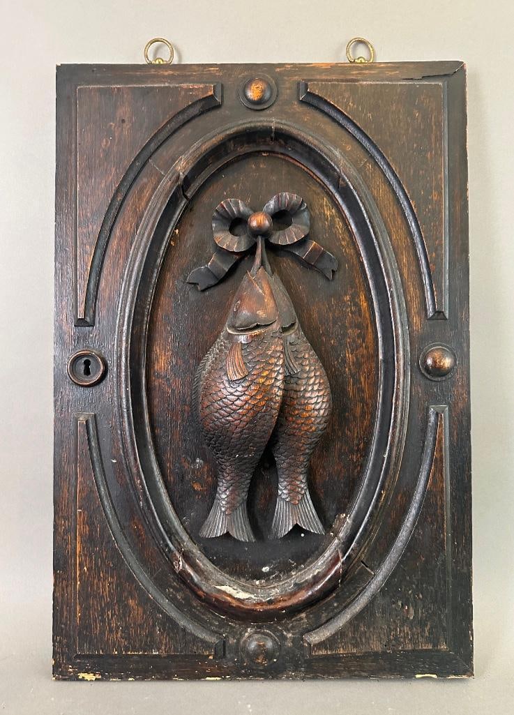 Natura Mortua Piscium Carved Wood Panel: Carved oak panel featuring a natura morte of fish on rope stringer within an oval cartouche. Eyelets attached at the top allow the panel to be displayed. Dimensions: 24" x 16". Condition: Fair, some c