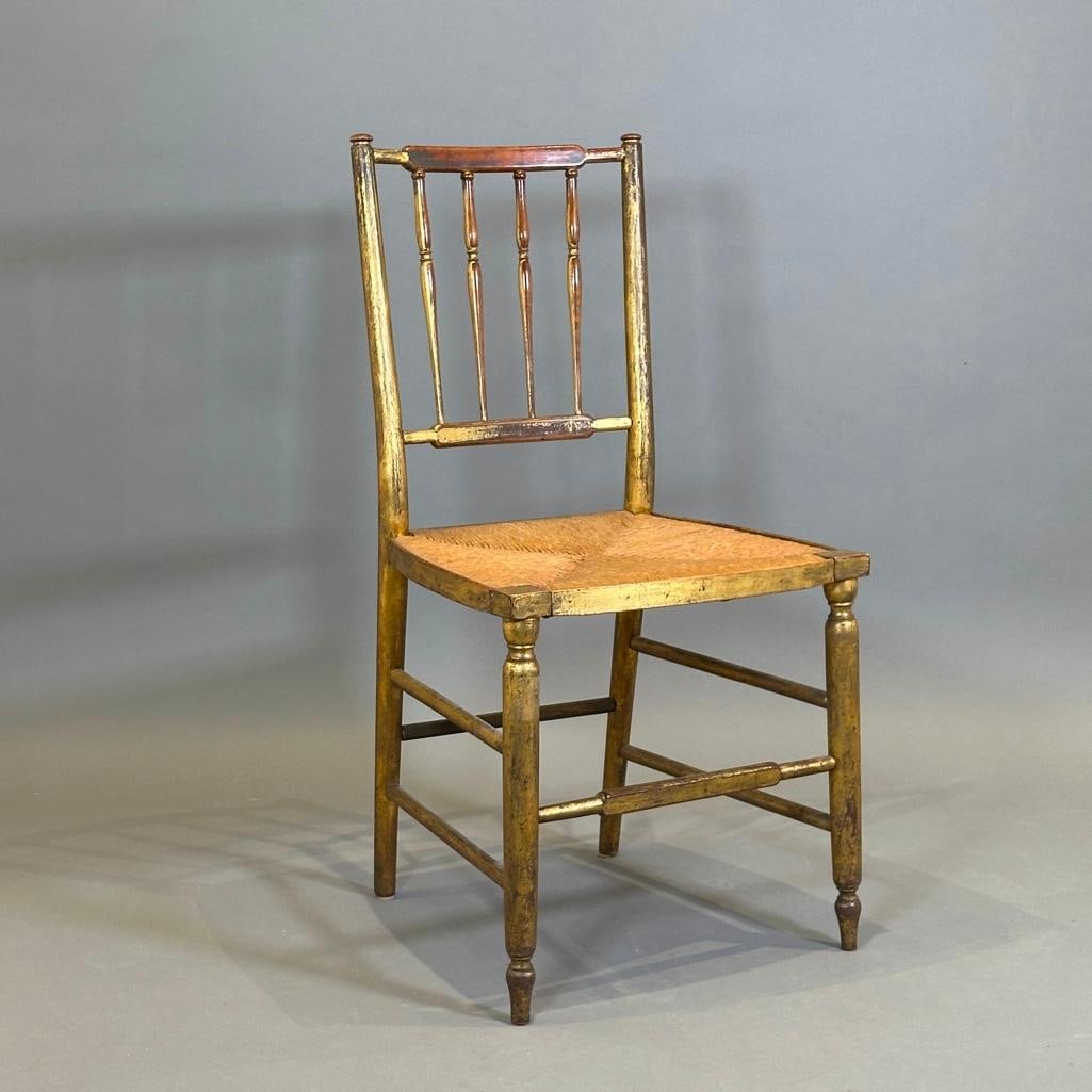 Gilded Country Sheraton Ballroom Chair: Gilded Country Sheraton Ballroom Chair, 19thc. Spindle back with gilding and traces of old green paint, over a rush seat, raised on turned legs joined by stretchers. Dimensions: 35 in.h. x 18 in.w.
