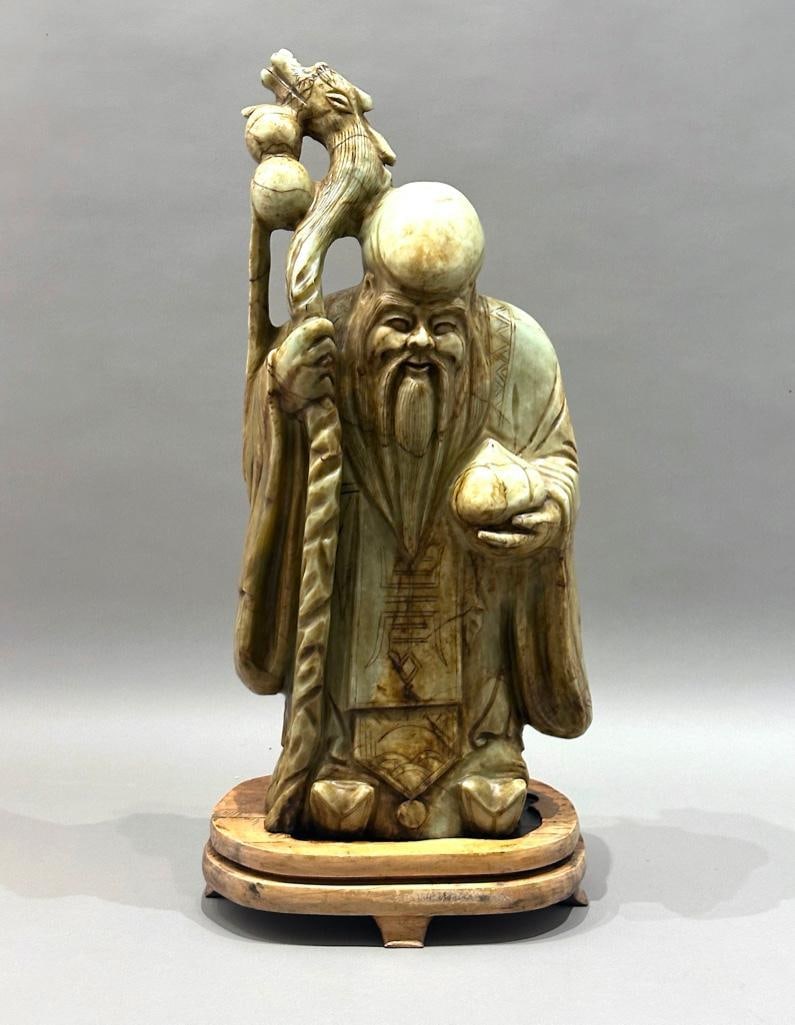 Very Large Carved Hardstone Figure of Chinese Immortal Shoulao: Very Large Carved Hardstone Figure of Chinese Immortal Shoulao, modern. One of the eight immortals, carrying the peaches of immortality, signifying a long life. Resting in fitted base. Dimensions: