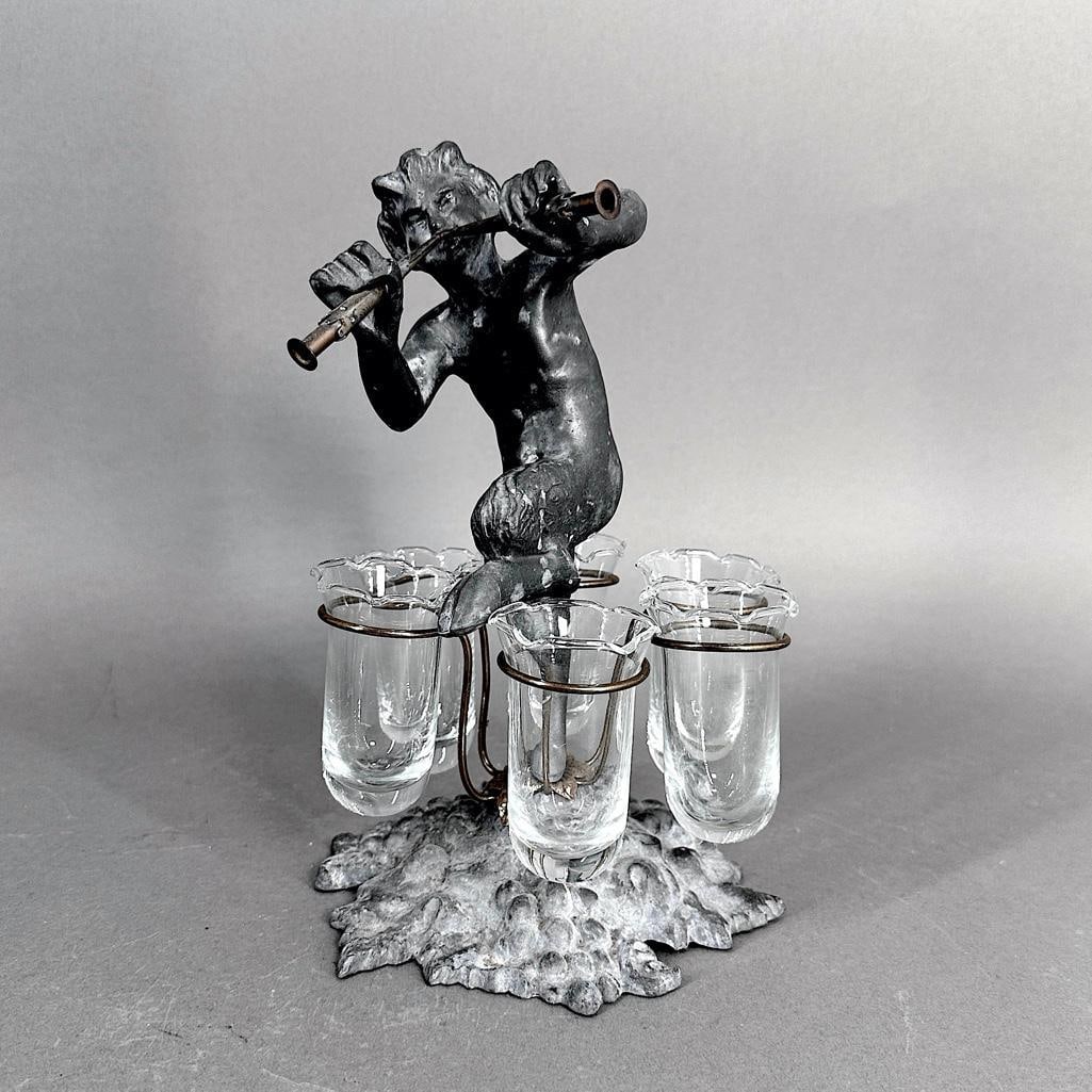 Petites Choses Lead, Brass and Glass Floral Epergne: Petites Choses Lead, Brass and Glass Floral Epergne, cast in lead as a young faun playing pipes, with six brass supports fitted with glass bud vases. Stamped 'Petites Choses' to base. Provenan