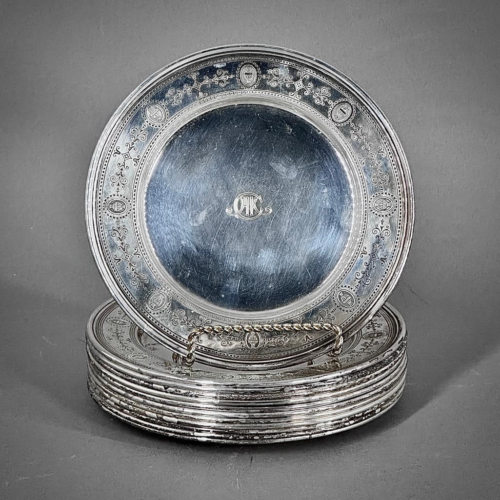 Twelve Tiffany & Co. Sterling Silver Bread and Butter Plates: Twelve Tiffany & Co. Sterling Silver Bread and Butter Plates, decorated with urns in cartouches and stylized scroll forms to the border, monogrammed HKC to the center, inscribed 1927 to the obvers