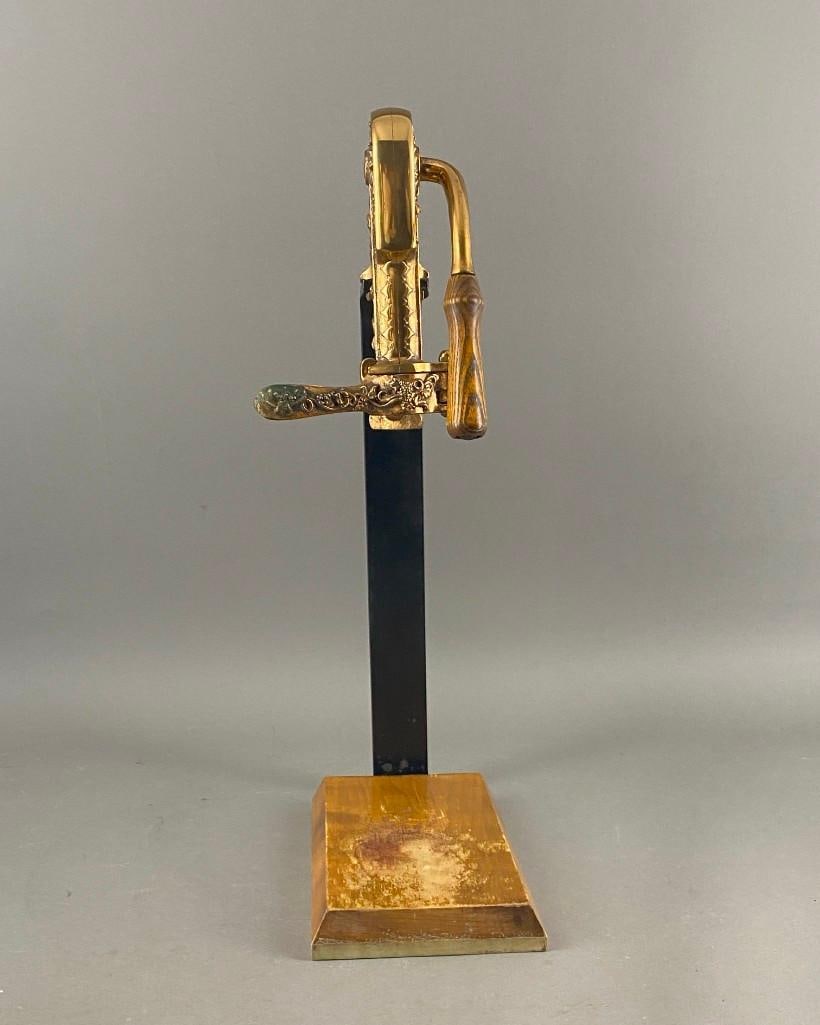 Vintage Vintner Brass Wine Opener: Vintage Vintner Brass Wine Opener, brass cast with cherubs frolicking in grapevines, with iron support and wood base. Dimensions: 33.5 in.h. Condition: Very good with wear from use.