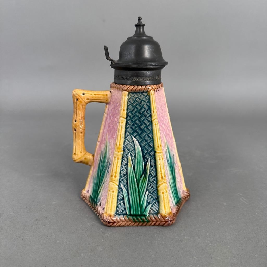 19th Century Etruscan Majolica Syrup Pitcher: The syrup pitcher is outlined in bamboo relief and the divided bamboo sections are decorated with alternating pink and green sections with green leaves, bamboo handel and pewter cover. Apprx 7-1/2"