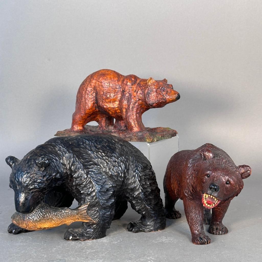 Black Forest Bears: Two black forest carved bears, 5.5"T and 5"T, one holding a Salmon fish, the other with painted open mount and glass eyes, the third bear is not Black Forest however nicely rendered bear with 