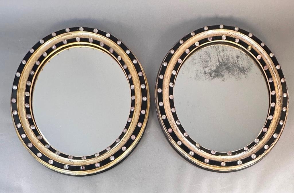 Pair of Irish Ebonized, Jewelled and Gilt Oval Wall Mirrors, 19th Century: Oval ebonized and parcel gilt mirrors, fitted with faceted and round jewelled beads, each apprx 22.25 x 18.25 inches oval. One with antique glass, the second with replacement glass. Hooks to top and s