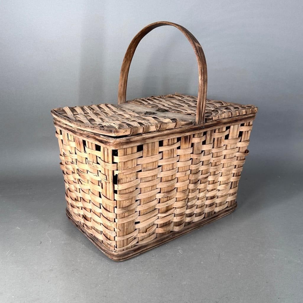 Antique Woven Picnic Basket: Antique Woven Picnic Basket, rectangular form with handle, with two hinged covers. Dimensions: 19.5 in.h. x 15 x 9 in. Condition: Some broken reeds.